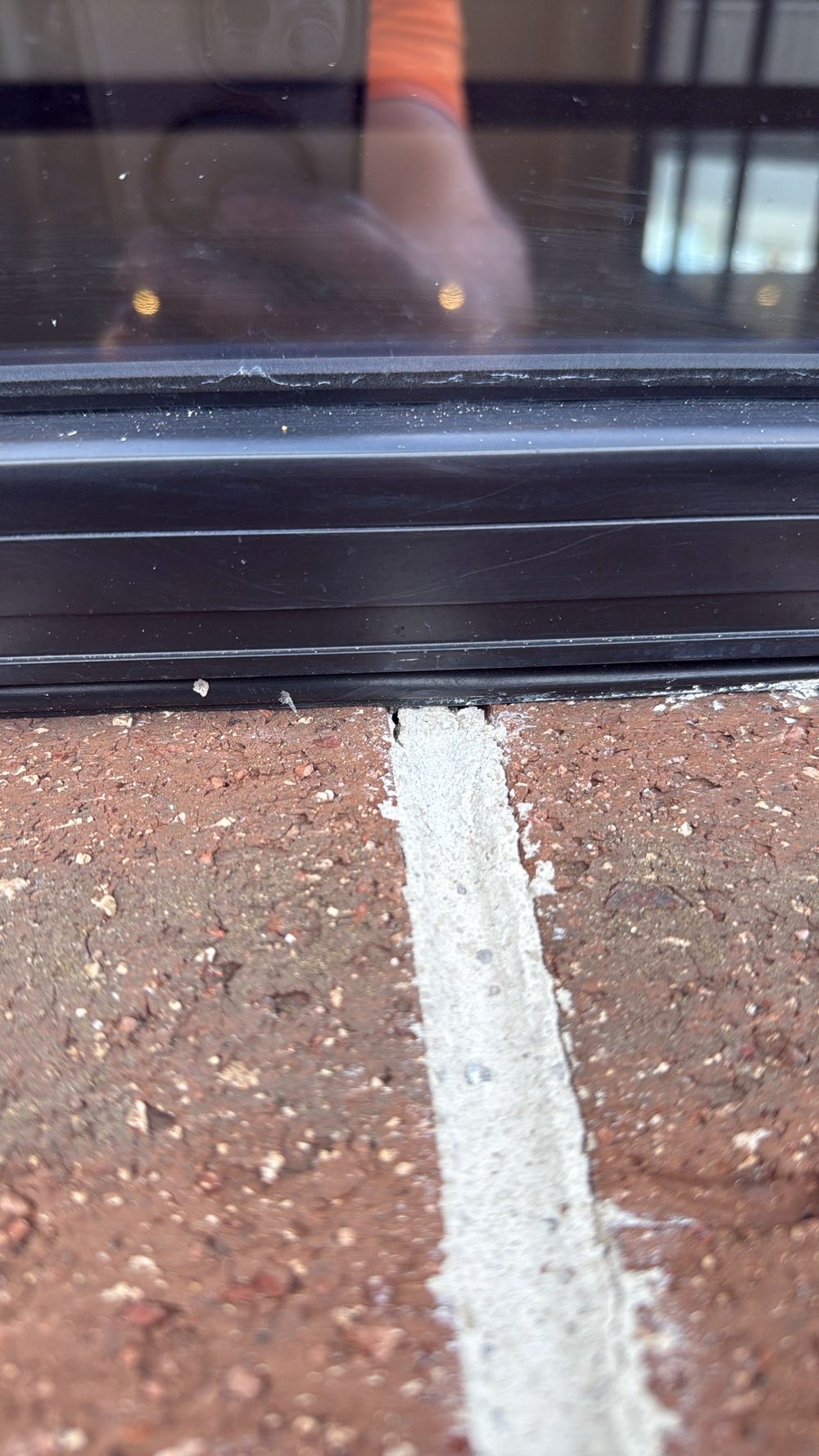 Open mortar joints in face brickwork beside a window frame, Pakenham