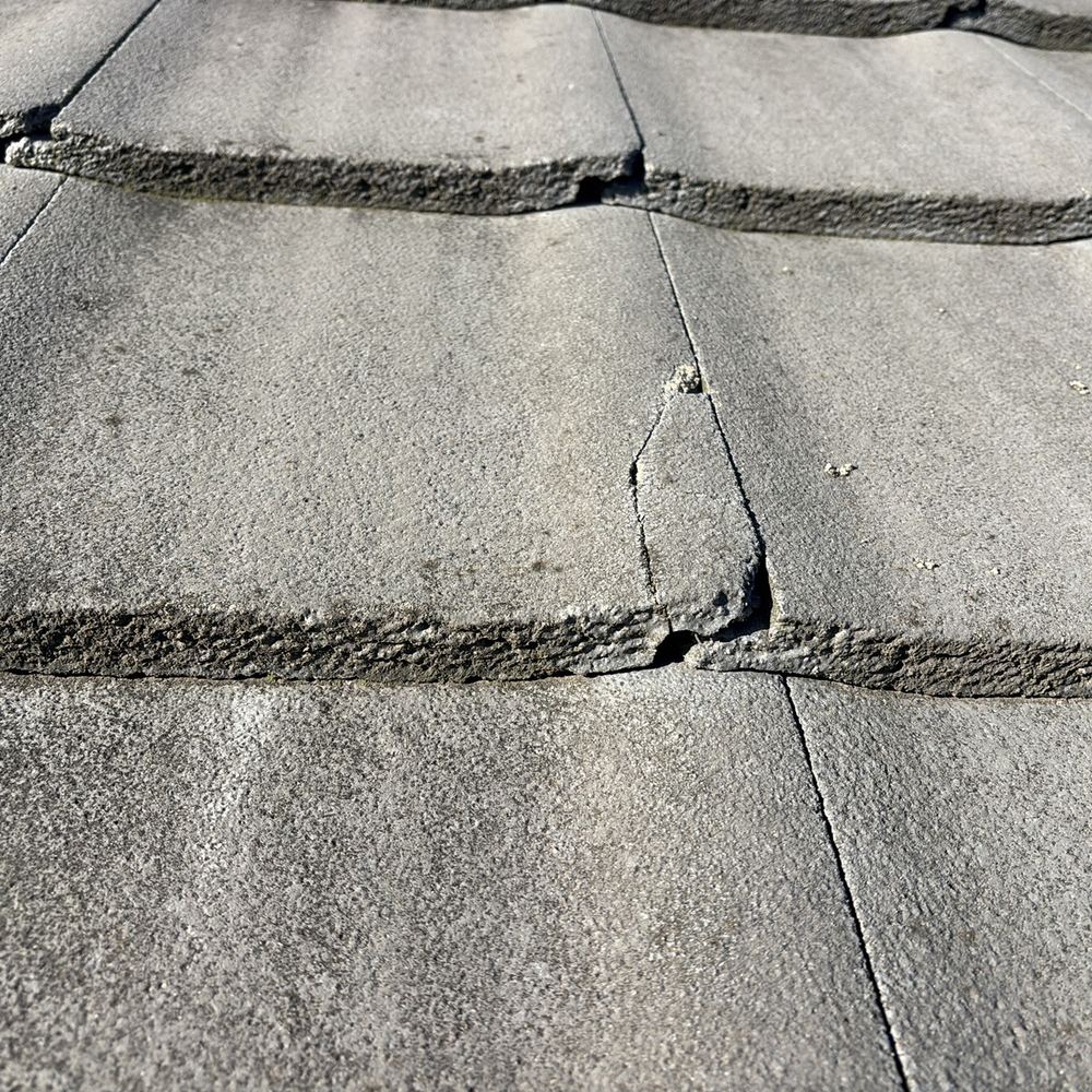 Cracked concrete roof tile that will eventually let water into the roof, found during a pre-purchase inspection in Pakenham