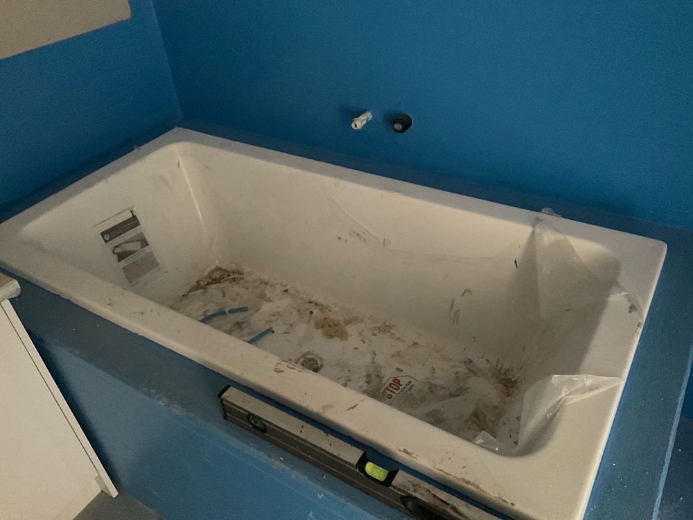 Installed bath left without a protective cover during construction, found during a waterproofing inspection in Pakenham